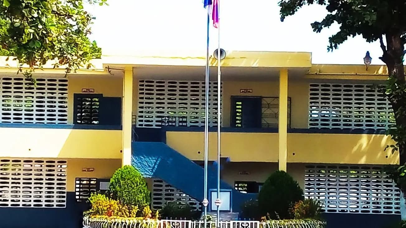 Le bâtiment jaune et bleu du Collège Pratique du Nord, ses deux mâts devant l'entrée.