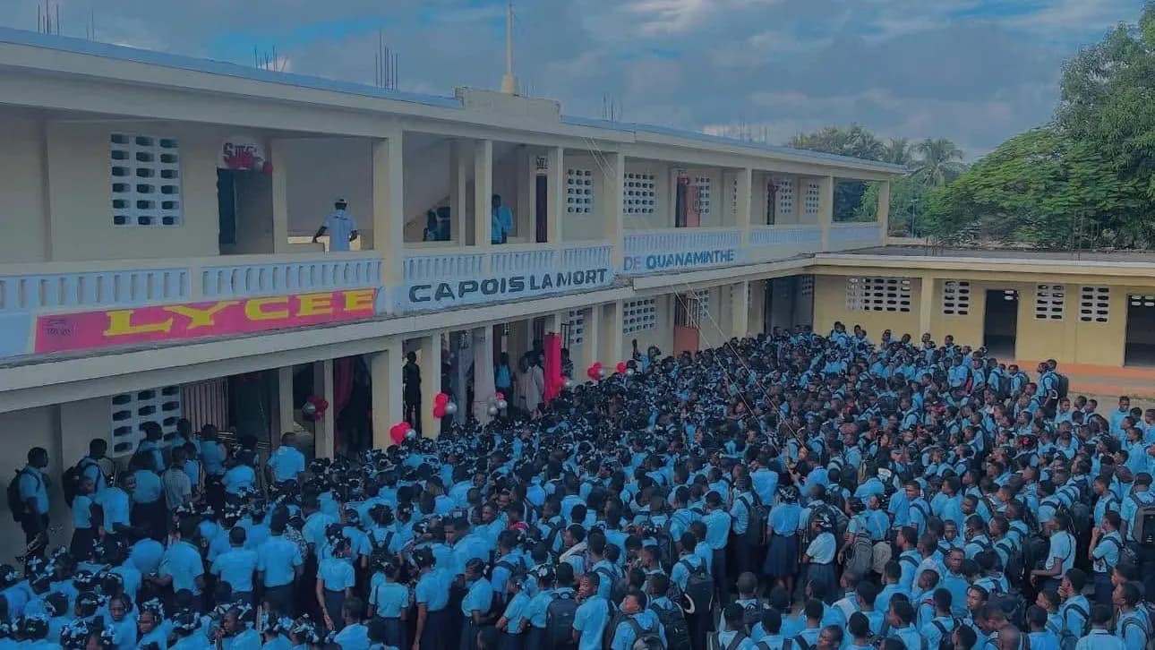 Les élèves du Lycée Capois la Mort, en uniforme bleu, rassemblés dans la cour devant le bâtiment.